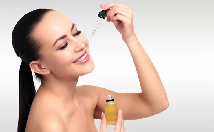 woman applying serum to her face